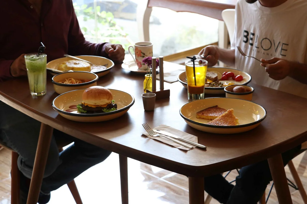 Two people enjoying a brunch meal indoors, creating a warm, cozy atmosphere.